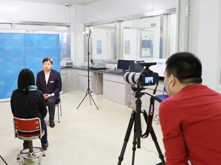 图为摄像师拍摄超威集团市场部总监杨享川接受记者采访画面